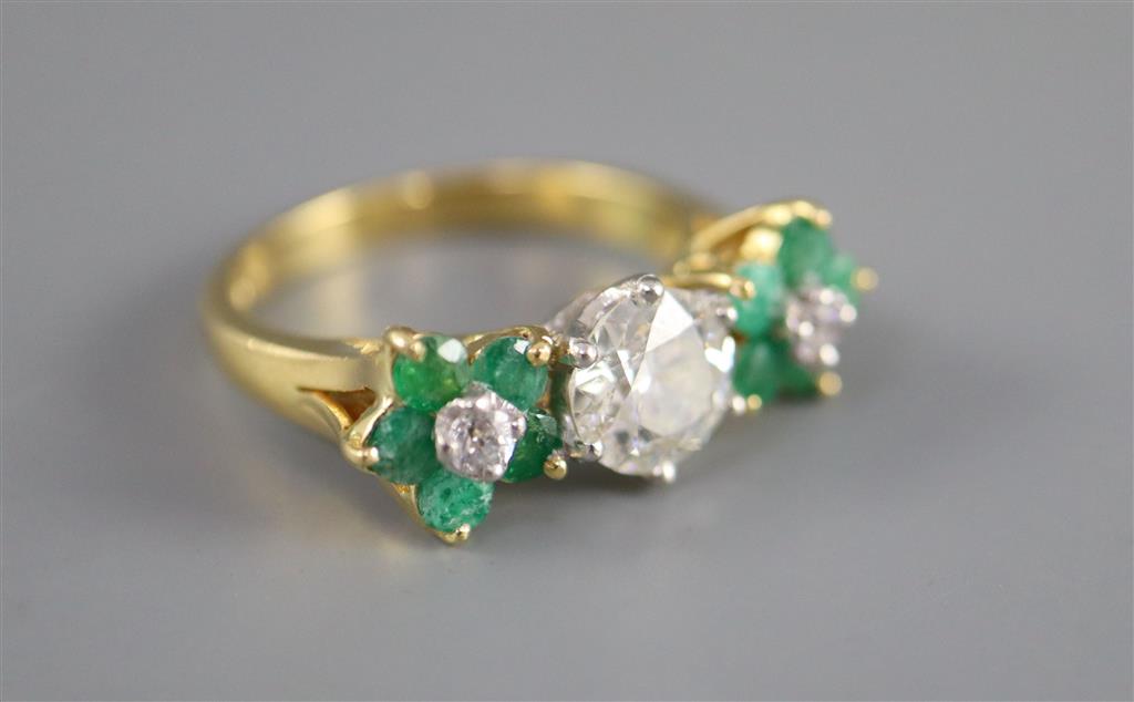 A modern 18k emerald and diamond set dress ring,